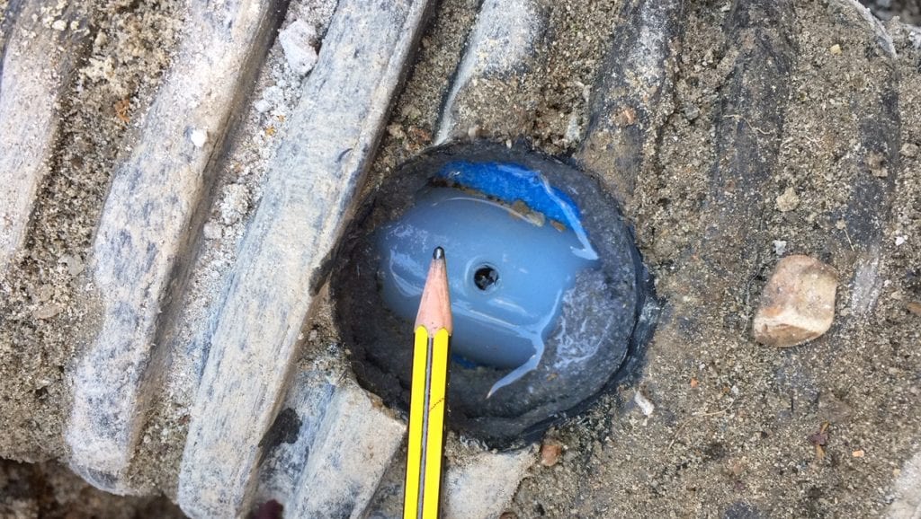A leaking pinhole in an underground heating pipe on a United Kingdom farm which required a live leak repair