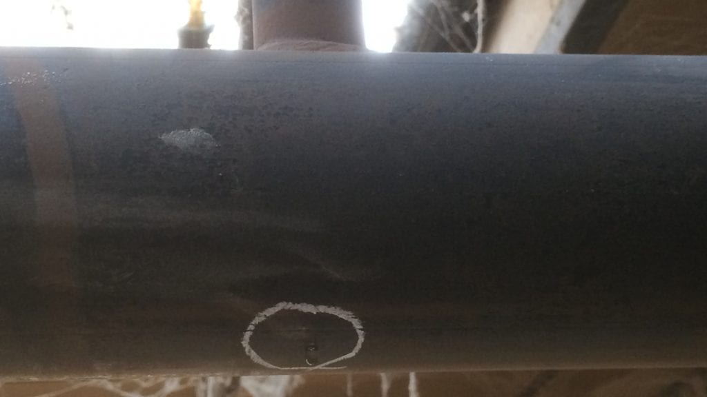 A pinhole leak on a steel pipe tee junction prior to being repaired using Superfast Steel Epoxy Putty