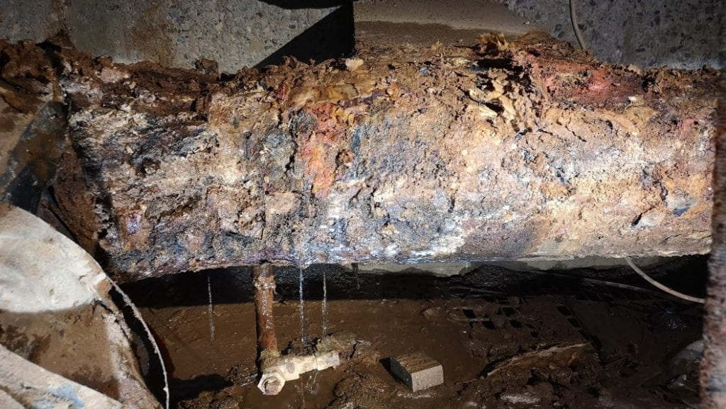 A leaking and heavily corroded pipe in a district heating system in the UK